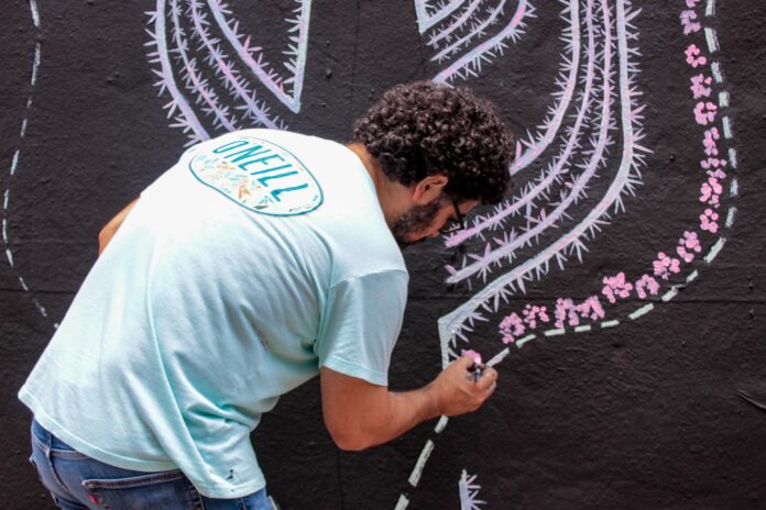 Artista pintando un mural ambiental en el Callej?n R?o Bravo